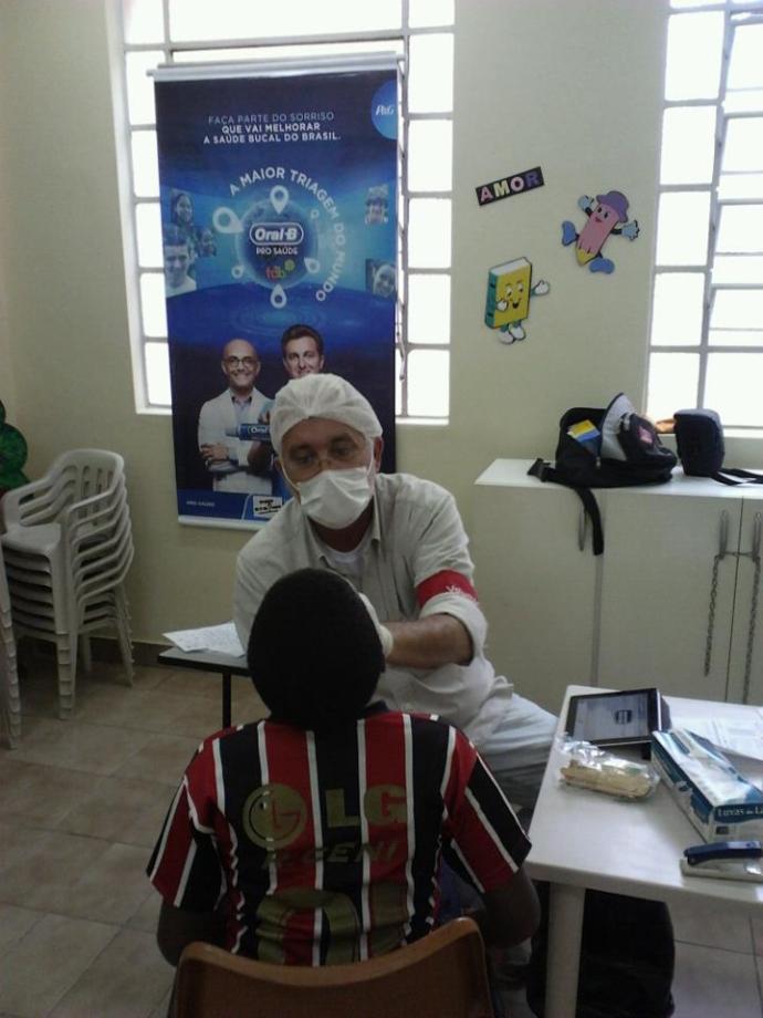 Dr. Luiz Scott, dentista voluntário, atendendo os adolescentes do Gol de Honra